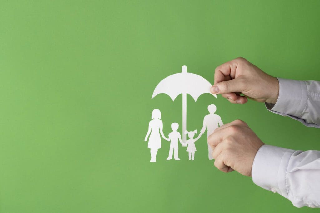 A man is drawing a family under an umbrella on a green background.