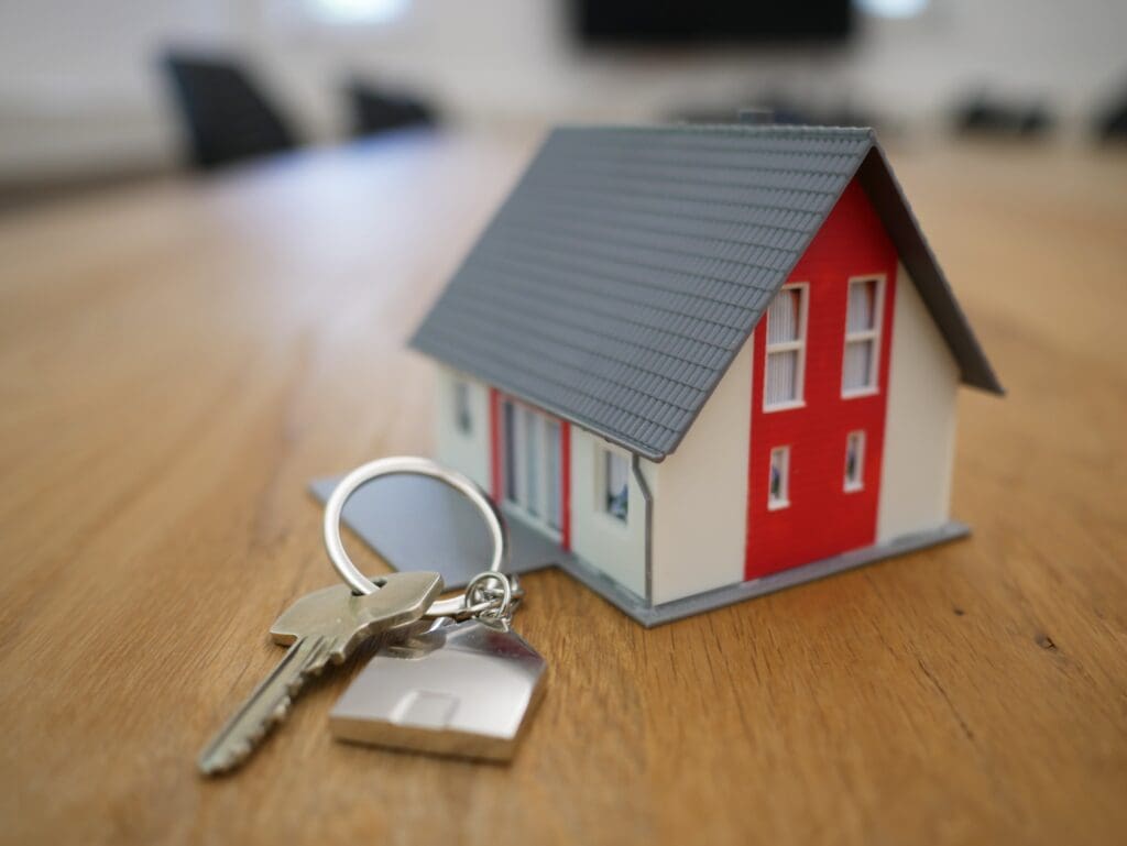 A model of a house with keys on a table.